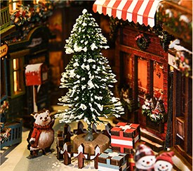 Besneeuwde kerstboom in het straatje van Christmas Street Corner