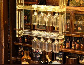 Verlicht wijnglazenrek achter de bar van Corner Tavern